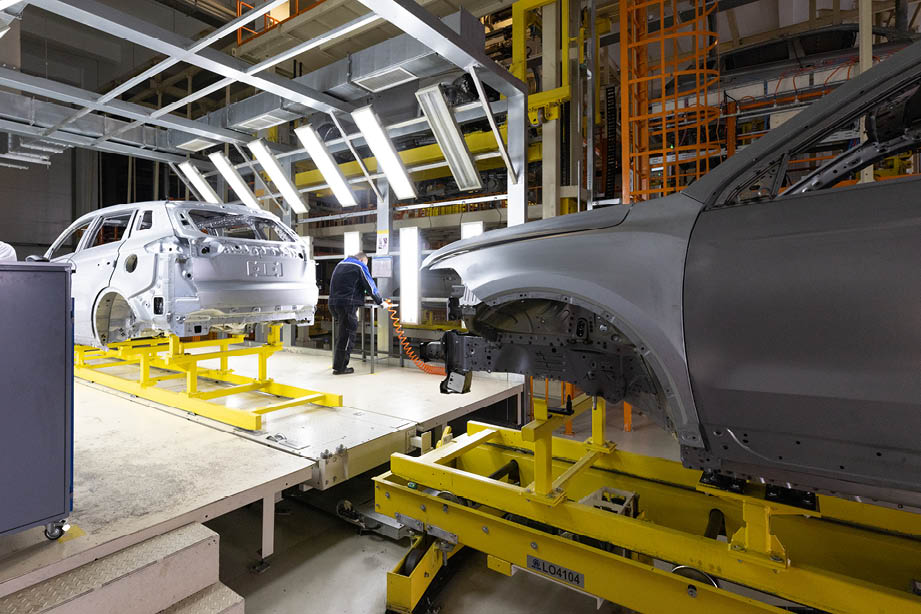 Car bodies are on assembly line. Factory for production of cars. Modern automotive industry. A car being checked before being painted in a high-tech enterprise.