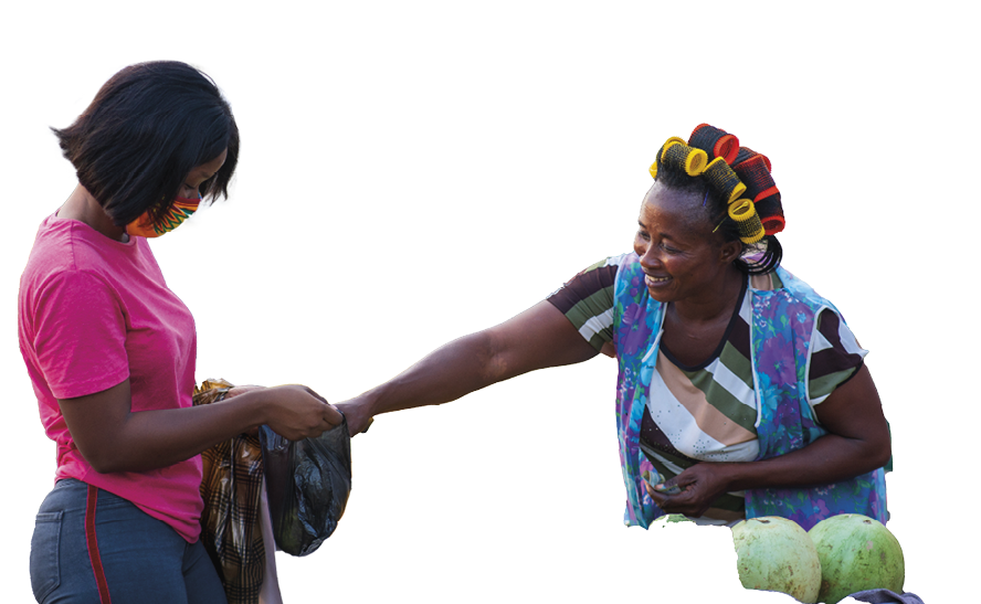 An African American female in a protective face mask shopping for fruit at a market