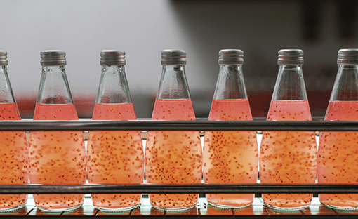 Product of Basil seed with fruit on the conveyor belt in the beverage factory. Bottling line for processing and bottling Basil seed with fruit into bottles. Food, health and Beverage industry
